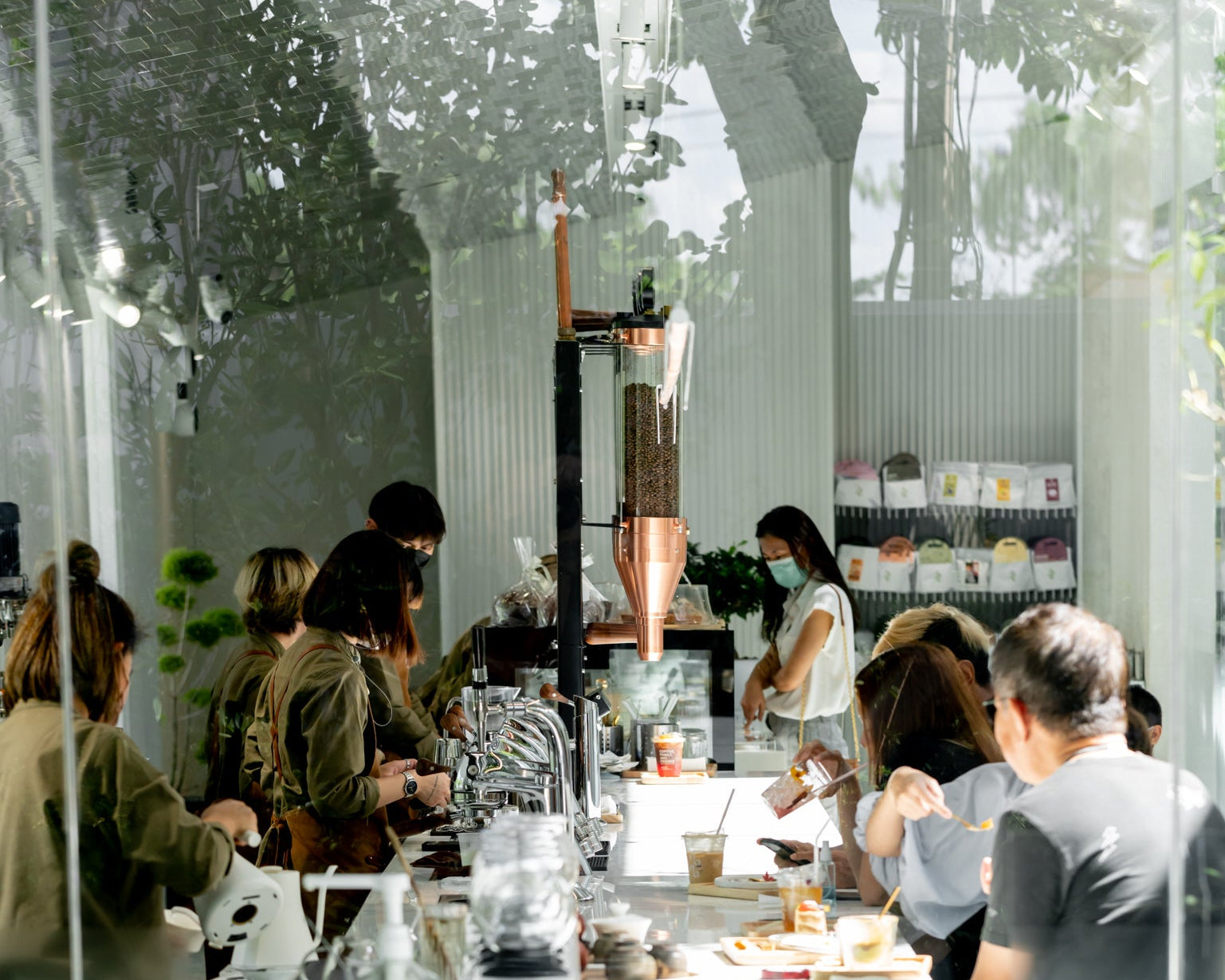 Nana coffee roasters area with people seated at tables, large windows allowing natural light to enter.